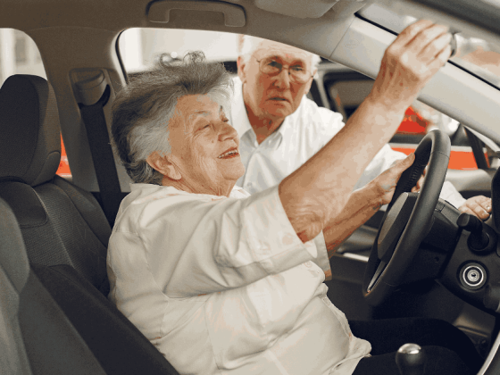 Casal de idosos em salão de automóveis avalia carro sem imposto