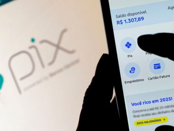 PIX Pensão: mão segura celular com aplicativo de pagamentos aberto