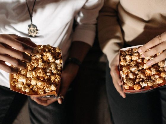 pessoas no cinema segurando pipoca, representando venda casada no cinema
