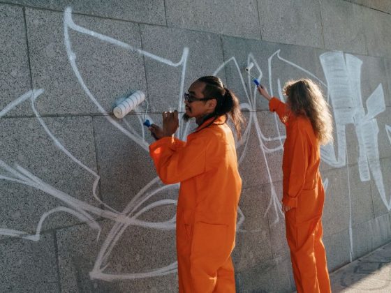 trabalho prisional — detentos com macacão laranja em serviço externo de limpeza urbana