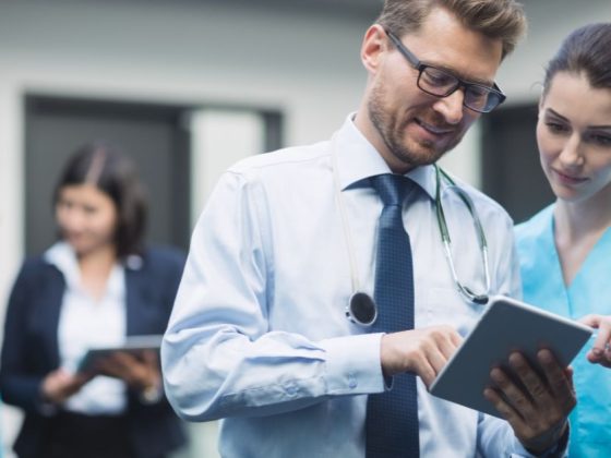 Profissionais de saúde consultam tablet em hospital, ilustrando o uso de IA no serviço público de BH