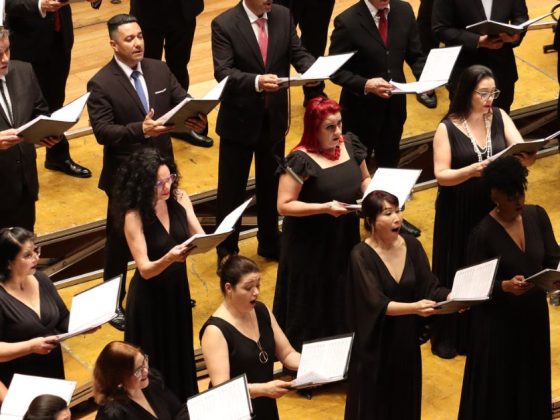 Coro da Osesp em apresentação no palco, com cantores segurando partituras