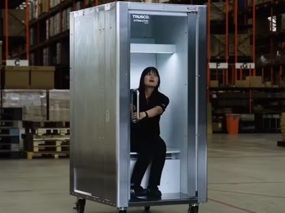 Mulher dentro de uma geladeira humana em galpão industrial com prateleiras ao fundo