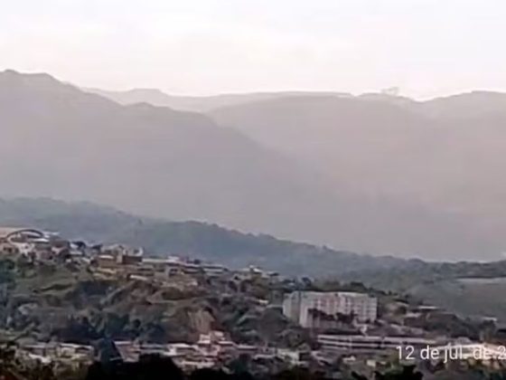 Nuvem de poeira encobre mineradoras em Congonhas vista de cima, com montanhas ao fundo, em 12 de julho de 2026