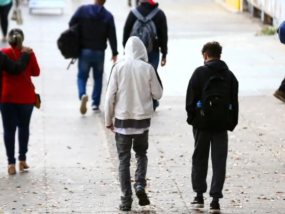 Pessoas com agasalho andando em calçada durante alerta de frio em BH