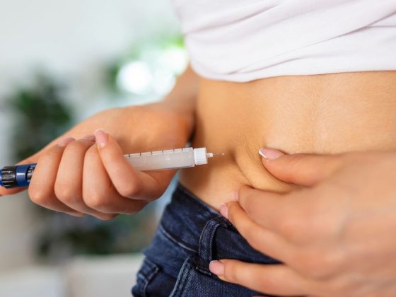 Mulher aplicando injeção de semaglutida na barriga com caneta injetável