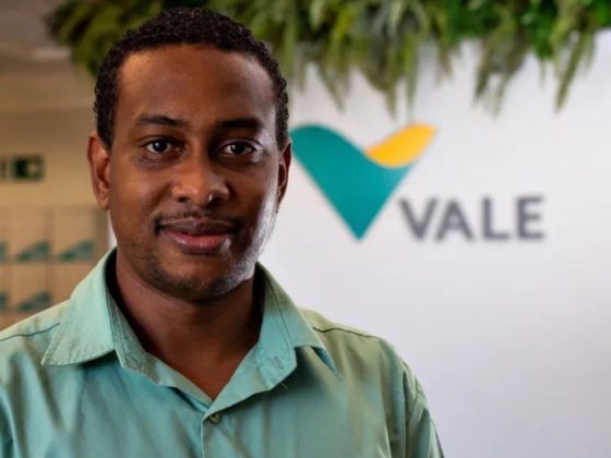Homem sorri em frente ao logo da Vale; empresa abre estágio técnico da Vale com 450 vagas em MG