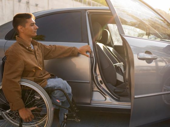 homem em cadeira de rodas abrindo porta de carro com isenção fiscal para PCD