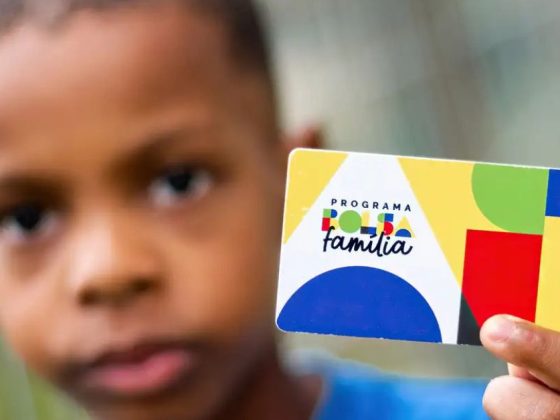 Criança segura cartão do Programa Bolsa Família, que paga adicionais do Bolsa Família a famílias cadastradas