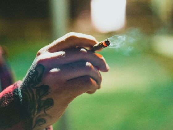multa por uso de drogas em BH: pessoa segura cigarro em espaço público