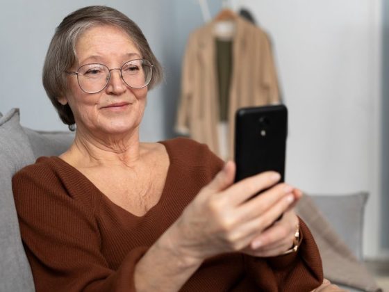 Mulher idosa usando smartphone para fazer Prova de Vida pelo celular em casa