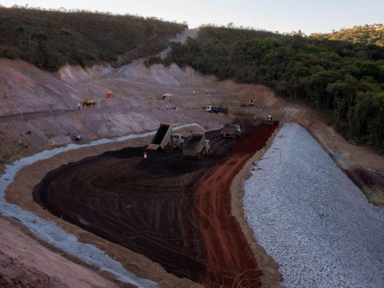 Área de operação de mineração com caminhões descarregando minério escuro em Congonhas, Minas Gerais, durante vazamento de minério em Congonhas