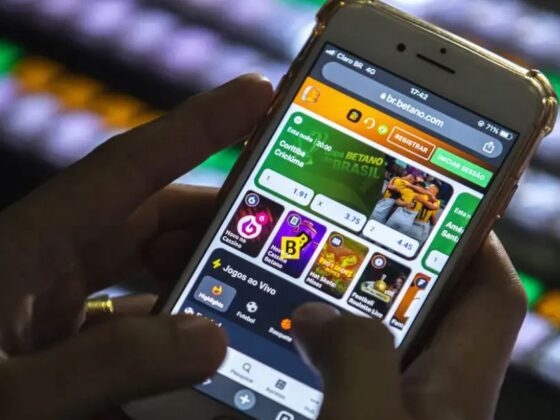 Mão segura celular com aplicativo de bets em Minas Gerais aberto na tela