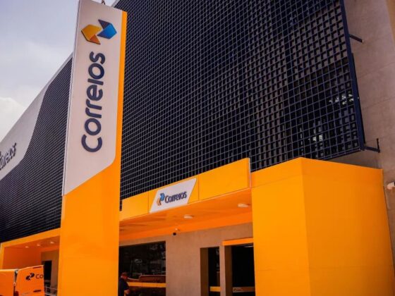 Fachada de agência dos Correios com faixas amarelas e laranja durante a greve dos Correios