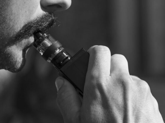 Homem fumando cigarro eletrônico, representando a necessidade da proibição dos cigarros eletrônicos.