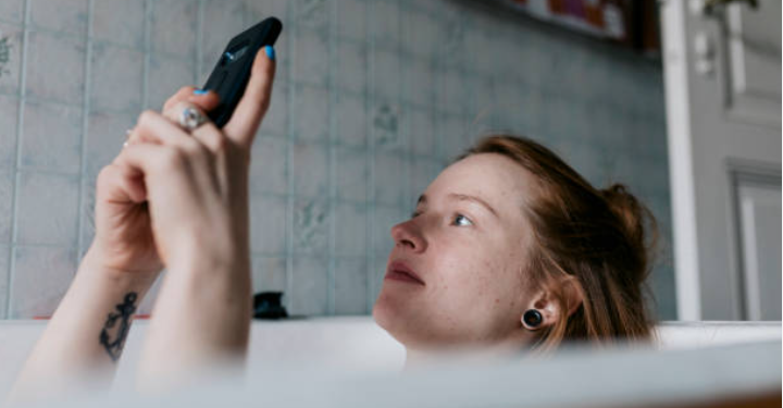 Mulher usando celular no banho