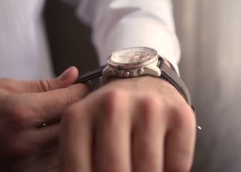 a man puts on a watch nv hand.