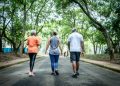 Fitness instructor walking with senior couple at public park