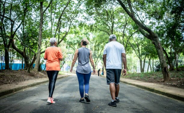 Fitness instructor walking with senior couple at public park