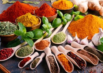 Variety of spices and herbs on kitchen table.