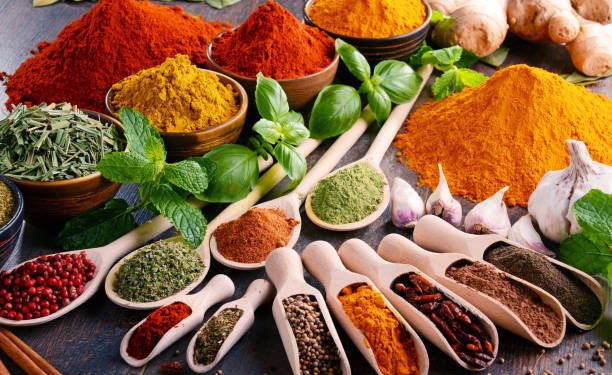 Variety of spices and herbs on kitchen table.