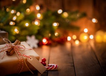 Brown Christmas gift box with a blank tag on rustic wooden table. High resolution 42Mp studio digital capture taken with Sony A7rII and Canon EF 70-200mm f/2.8L IS II USM Telephoto Zoom Lens