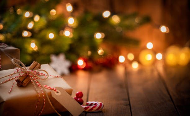 Brown Christmas gift box with a blank tag on rustic wooden table. High resolution 42Mp studio digital capture taken with Sony A7rII and Canon EF 70-200mm f/2.8L IS II USM Telephoto Zoom Lens