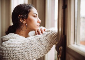 pensive woman in front of the window