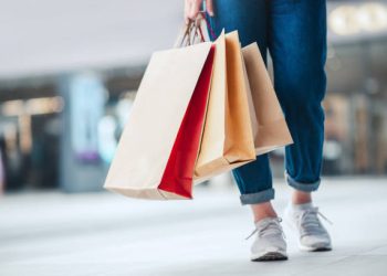 Closeup - Woman holding sale shopping bags. Consumerism, shopping, lifestyle concept