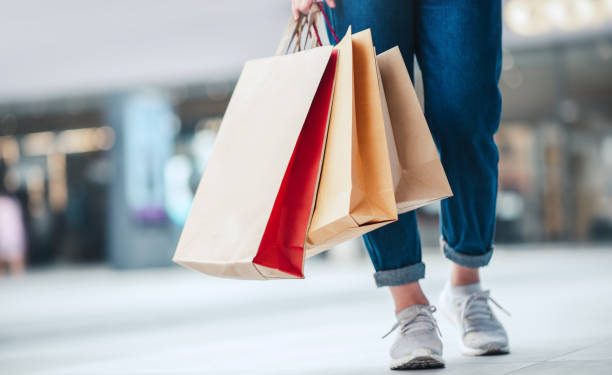Closeup - Woman holding sale shopping bags. Consumerism, shopping, lifestyle concept