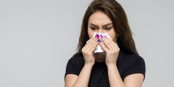 mulher tampando nariz