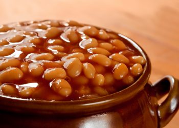 Baked beans in tomato sauce, in a brown pot.