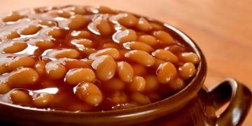 Baked beans in tomato sauce, in a brown pot.