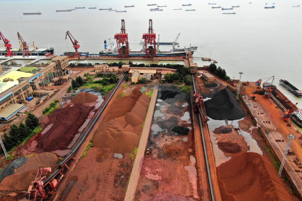 Pilhas de minério de ferro importado no porto chinês de Jiangsu. Crédito: Stringer/Reuters