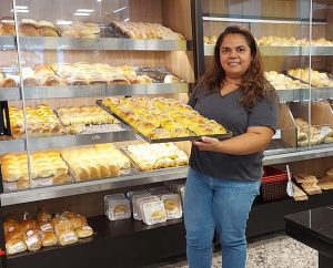 Mulher segurando tabuleiro de pães