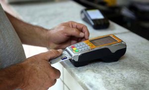 Pessoa passa cartão de crédito na maquininha