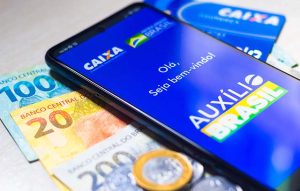 Notas de real e telefone celular em cima