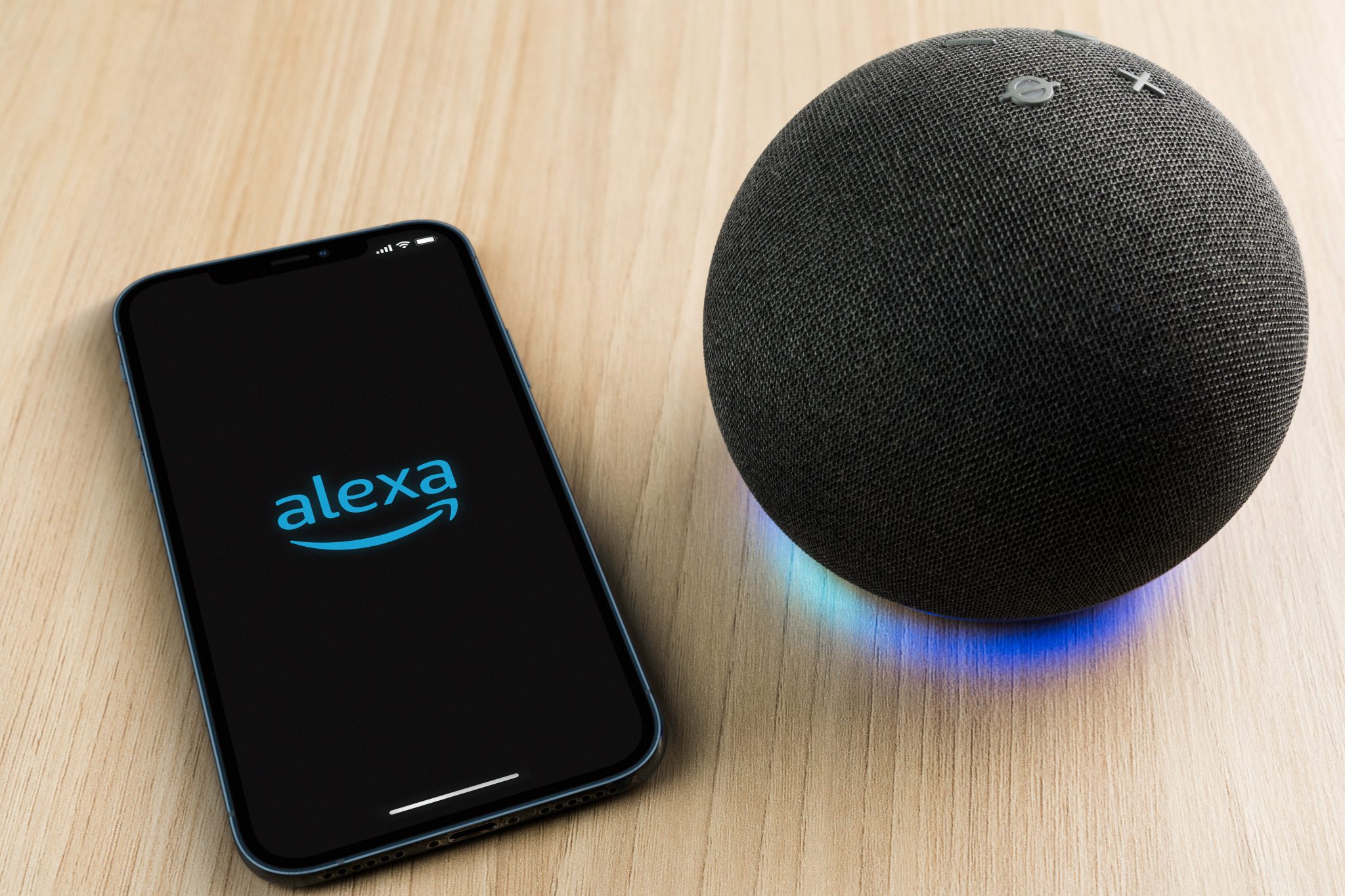 Alexa, Smart speaker and virtual assistant from Amazon company connected to smartphone app. Wooden background. Rio de Janeiro, RJ, Brazil. September 2021.