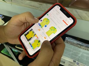 Pessoa faz pesquisa de camisas da seleção brasileira no smartphone