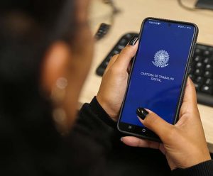 Mulher abre aplicativo da carteira de trabalho em celular