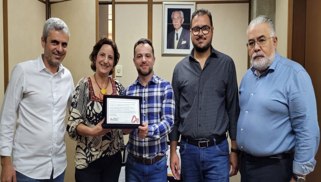 Pessoas segurando uma placa de homenagem
