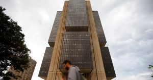 Homem caminha em frente ao prédio do Banco Central em Brasília