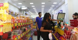 Mulher realiza o pagamento das compras em caixa de comércio