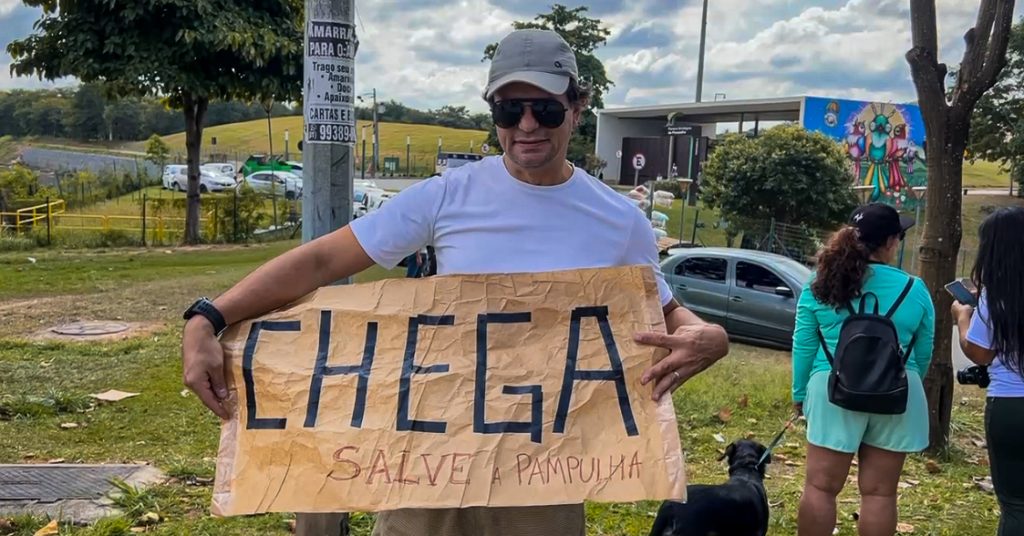 Morador da Pampulha participando de mobilização com cartaz escrito: "Chega, salve a pampulha"