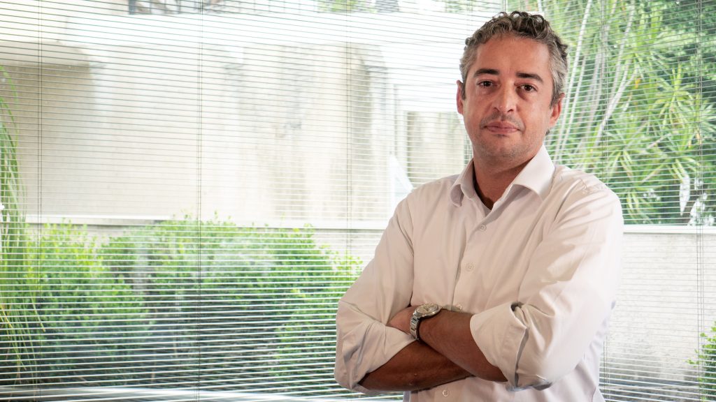 Homem de camisa social branca de braços cruzados