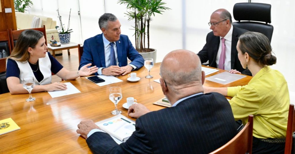 Pessoas sentadas à mesa conversando.