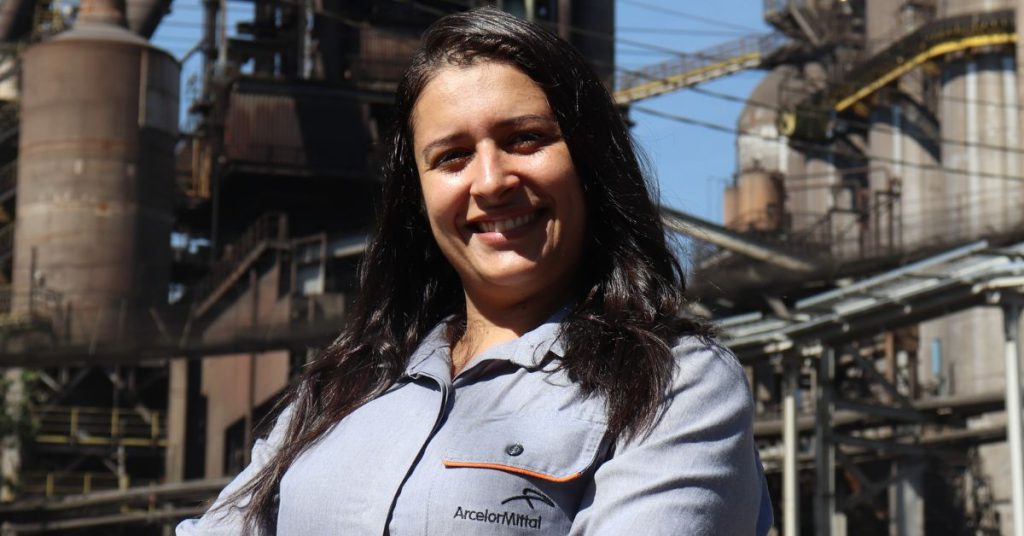 Mulher sorrindo nas instalações da ArcelorMittal