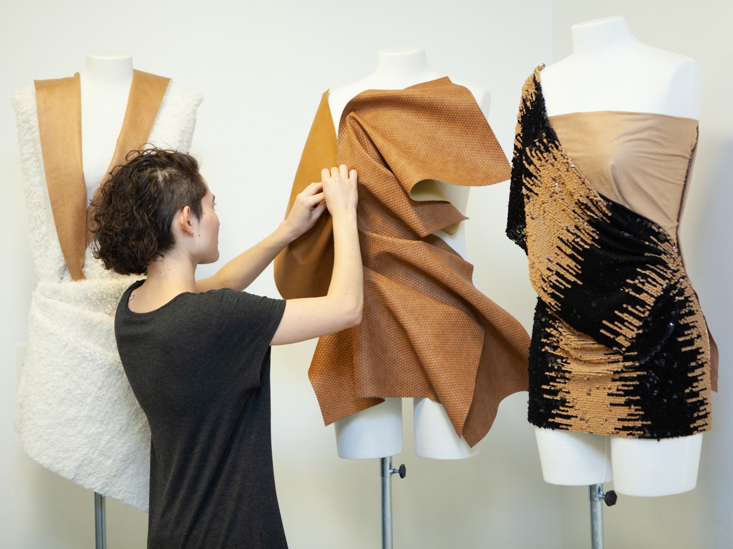 Estilista trabalhando com tecido sustentável em manequim de costura.
