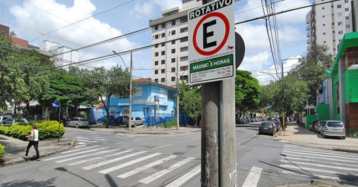 Cruzamento de ruas com uma placa de estacionamento rotativo fixada em um poste