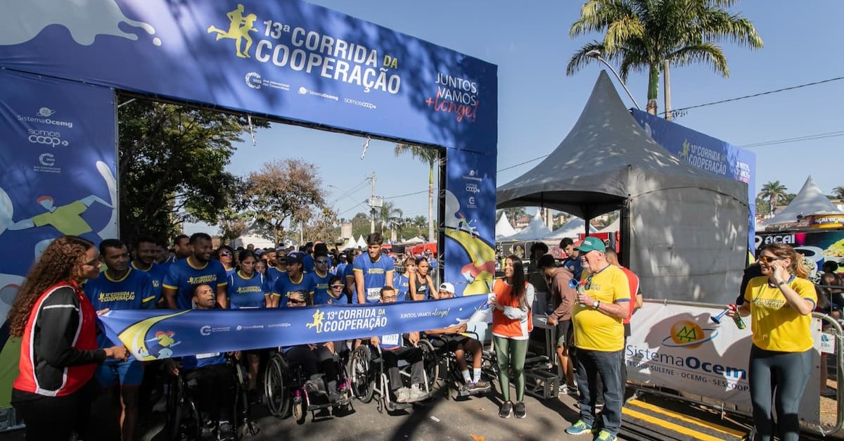 Grupo de corredores e cadeirantes posando na linha de largada da 13ª Corrida da Cooperação.